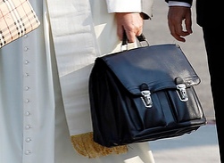 Pope Francis holds personal bag as he boards plane at airport in Rome