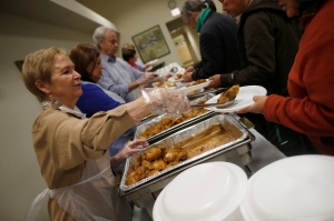 Volunteers serve people during free dinner provided by Chicago Catholic Charities