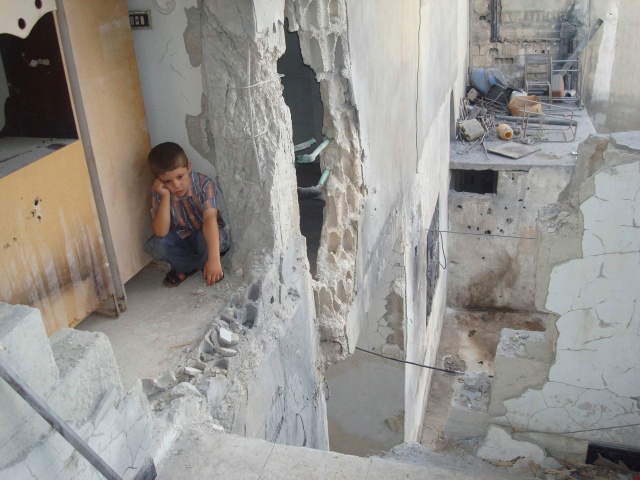 BOY SITS IN DAMAGED HOME AFTER SHELLING IN SYRIA