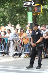 Crowds wait for Pope Francis’ motorcade to appear while a New York City police officer patrols the area on Sept. 25. Ticket-holders stood for hours just to get a glimpse of the pontiff as he made his way towards Madison Square Garden. (CNS photo/Seth Gonzales)